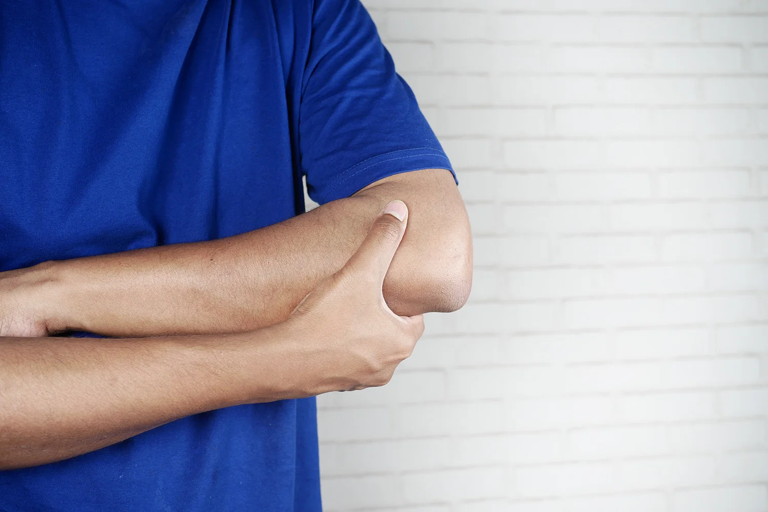 adult massaging sore elbow