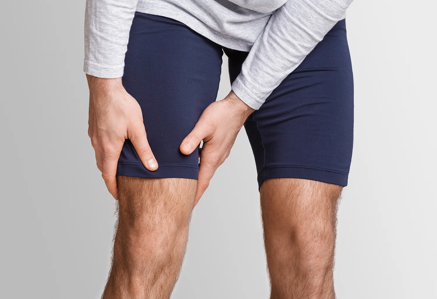 man holding thighs in discomfort