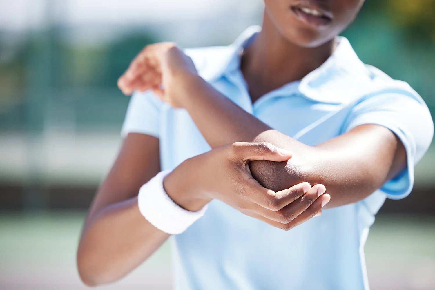 woman massaging her aching elbow