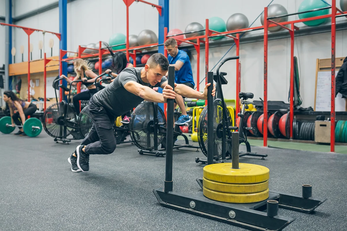 man training in the gym with a push